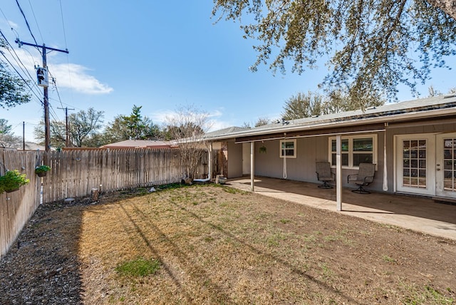 back of property with a patio area, a fenced backyard, and a yard