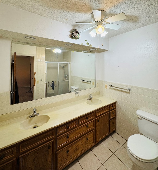 bathroom with a sink, a textured ceiling, toilet, and tile patterned floors