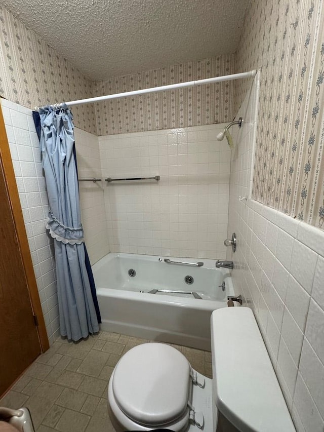 full bath featuring a textured ceiling, a wainscoted wall, tile walls, shower / bath combo, and wallpapered walls