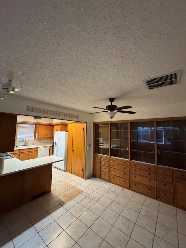 kitchen with white appliances, visible vents, light countertops, a sink, and light tile patterned flooring