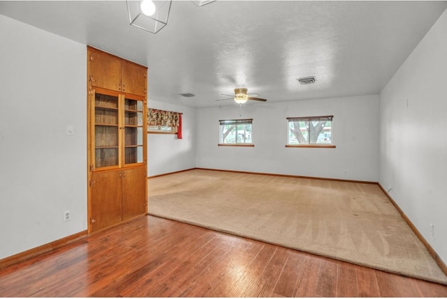 312 N Main St, Coahoma, TX 79511 - unfurnished room featuring wood finished floors, visible vents, a ceiling fan, and baseboards
