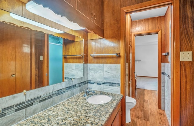 312 N Main St, Coahoma, TX 79511 - half bathroom featuring backsplash, wood finished floors, vanity, and toilet
