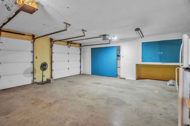 312 N Main St, Coahoma, TX 79511 - garage with a garage door opener and freestanding refrigerator