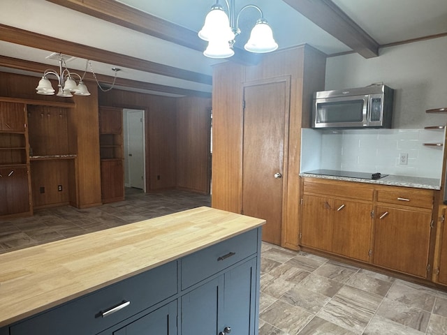 2615 W Golf Course Rd, Midland, TX 79705 - kitchen with a chandelier, stainless steel microwave, butcher block countertops, tasteful backsplash, and beam ceiling