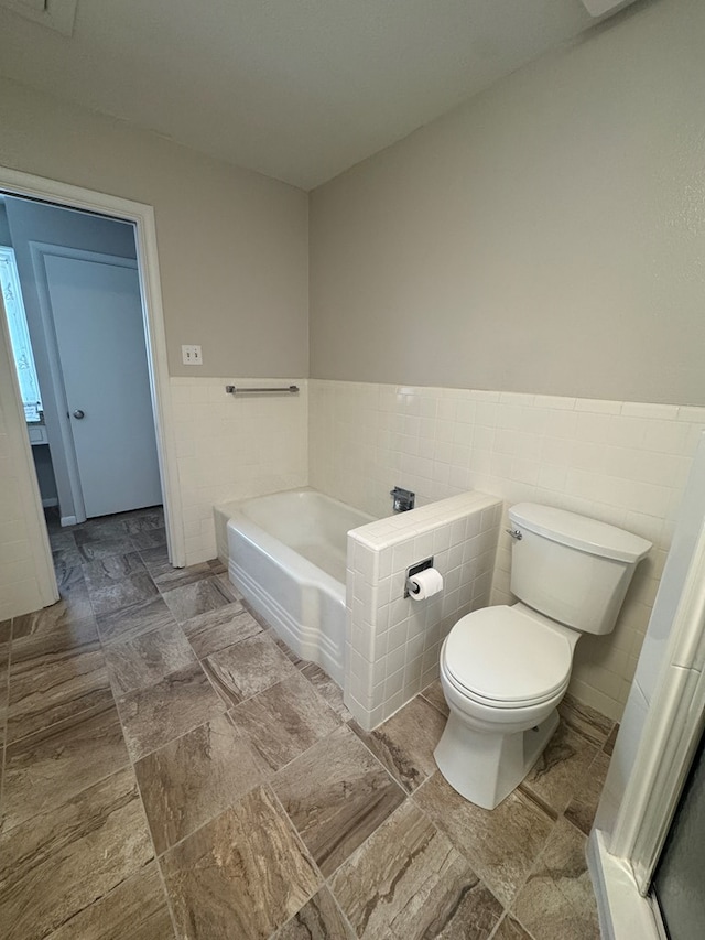 2615 W Golf Course Rd, Midland, TX 79705 - bathroom featuring a bath, tile walls, and a wainscoted wall