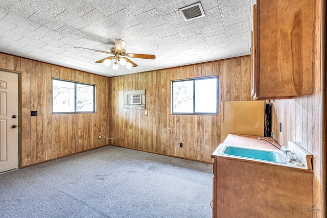 empty room featuring ceiling fan, light colored carpet, an AC wall unit, and sink