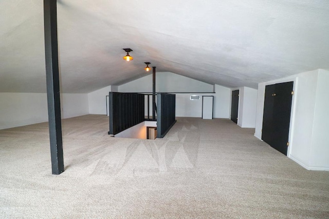 bonus room with light colored carpet and lofted ceiling