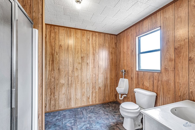 bathroom with wooden walls, vanity, and toilet