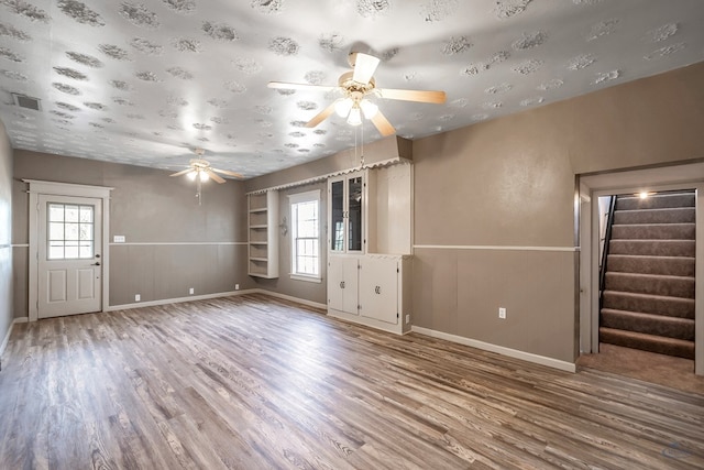 unfurnished living room with hardwood / wood-style flooring and ceiling fan