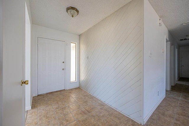 foyer featuring visible vents and a textured ceiling