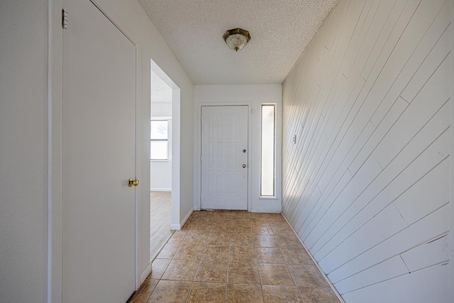 foyer with a textured ceiling and baseboards