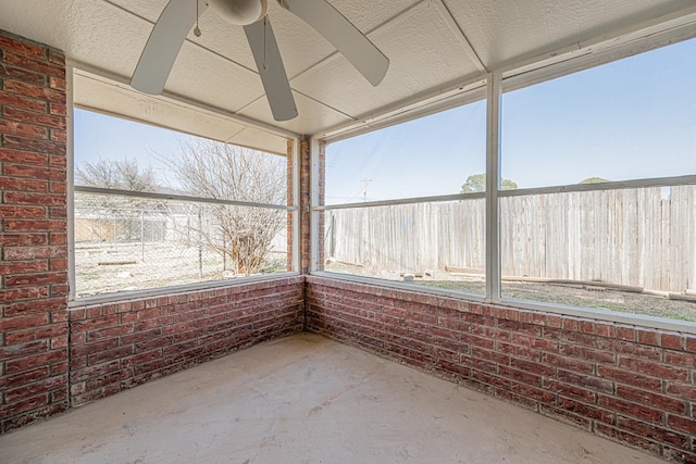 unfurnished sunroom with ceiling fan