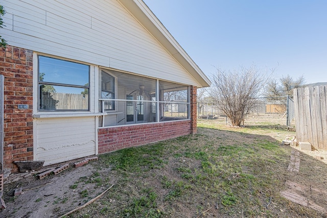 view of yard featuring a sunroom and fence