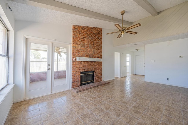 unfurnished living room featuring a brick fireplace, ceiling fan, lofted ceiling with beams, and a textured ceiling