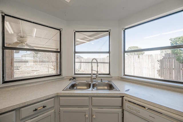 kitchen featuring light countertops, a sink, and dishwasher