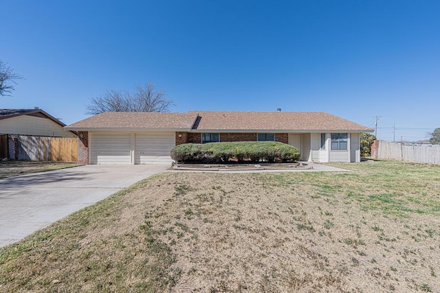 single story home featuring brick siding, concrete driveway, an attached garage, fence, and a front yard