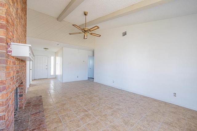 unfurnished living room with baseboards, visible vents, a textured ceiling, a brick fireplace, and beam ceiling