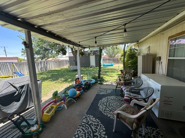 view of patio with a storage unit, an outdoor structure, and a fenced backyard