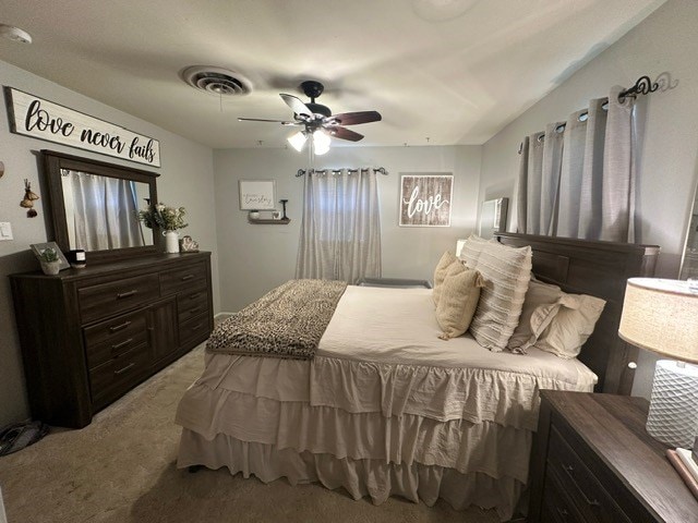 bedroom with visible vents, ceiling fan, and carpet flooring