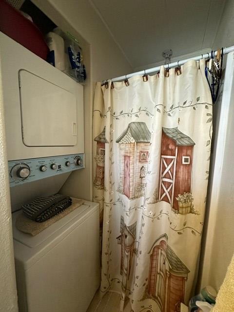 laundry area featuring stacked washer and clothes dryer and laundry area