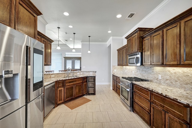 kitchen featuring a peninsula, appliances with stainless steel finishes, a sink, and backsplash