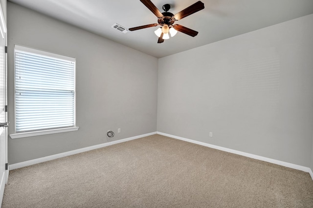 carpeted empty room with visible vents, ceiling fan, and baseboards
