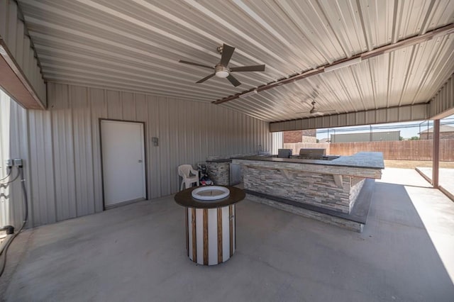 view of patio / terrace with an outdoor kitchen, fence, and a ceiling fan