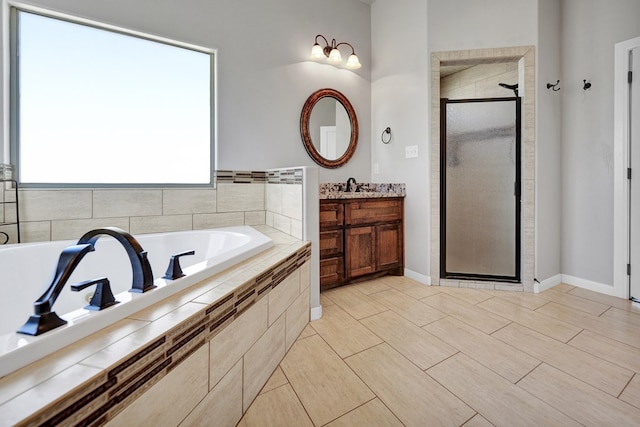full bathroom with a stall shower, a garden tub, and vanity