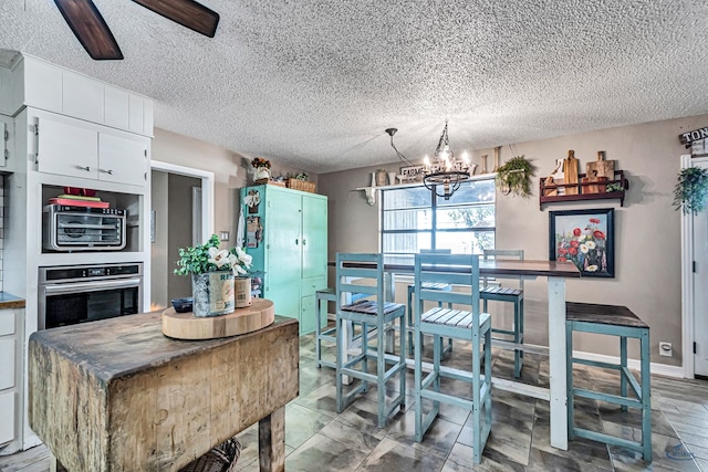 1412 Sparks St, Midland, TX 79701 - dining area with a chandelier, a textured ceiling, and a ceiling fan