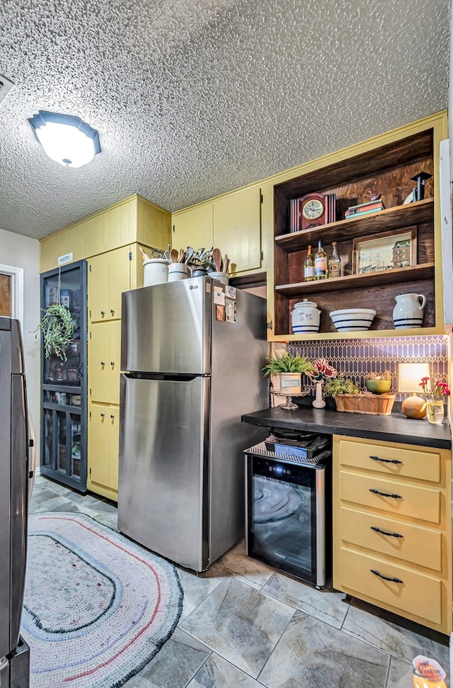 1412 Sparks St, Midland, TX 79701 - kitchen with freestanding refrigerator, open shelves, dark countertops, wine cooler, and a textured ceiling