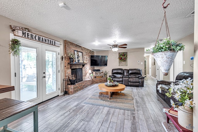 1412 Sparks St, Midland, TX 79701 - living area with a textured ceiling, wood finished floors, ceiling fan, a brick fireplace, and french doors