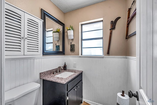1412 Sparks St, Midland, TX 79701 - bathroom with toilet, wainscoting, vanity, and a textured ceiling