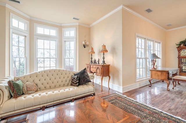 living room featuring hardwood / wood-style floors, crown molding, and a healthy amount of sunlight