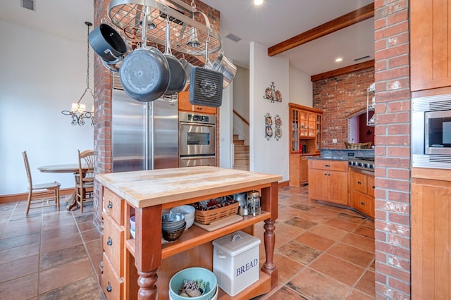 kitchen featuring built in appliances, butcher block countertops, beamed ceiling, and a chandelier