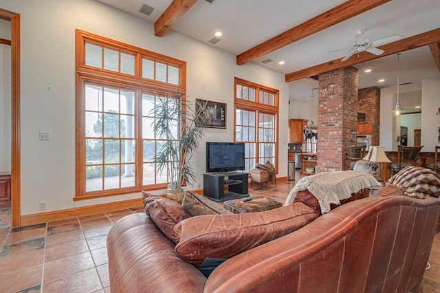 tiled living room featuring beamed ceiling, ornate columns, and ceiling fan