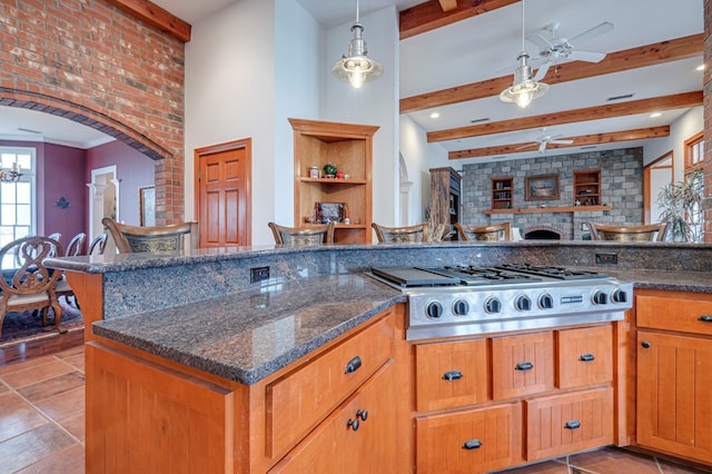 kitchen with ceiling fan, beamed ceiling, hanging light fixtures, and stainless steel gas cooktop