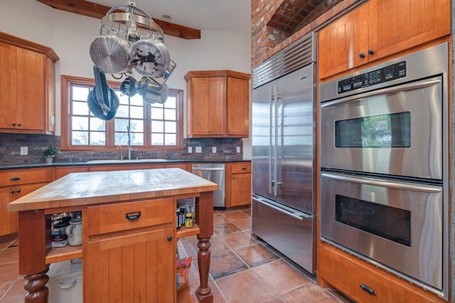 kitchen with backsplash, a center island, sink, and appliances with stainless steel finishes