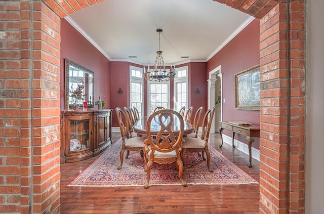 dining room featuring crown molding, dark hardwood / wood-style flooring, and a notable chandelier