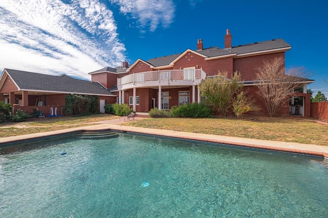 back of property featuring a fenced in pool and a lawn