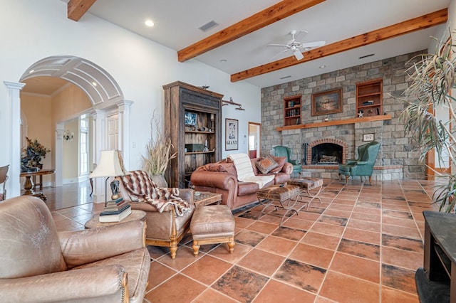 living room with beam ceiling, ceiling fan, decorative columns, and a brick fireplace