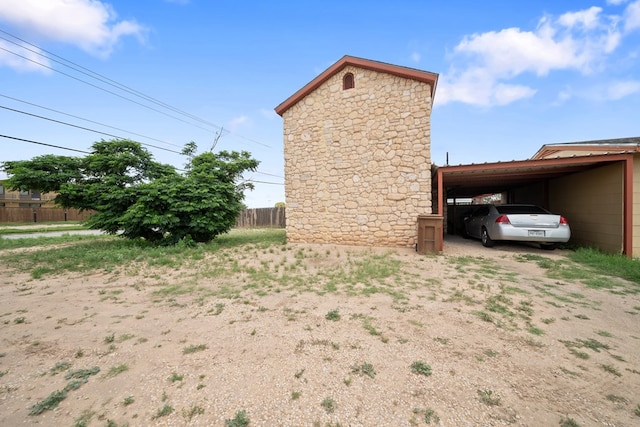 1101 Barnes Ave, Big Spring, TX 79720 - view of side of home with driveway, an attached carport, and stone siding