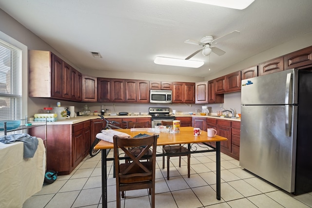 1101 Barnes Ave, Big Spring, TX 79720 - kitchen featuring appliances with stainless steel finishes, ceiling fan, light countertops, and light tile patterned flooring
