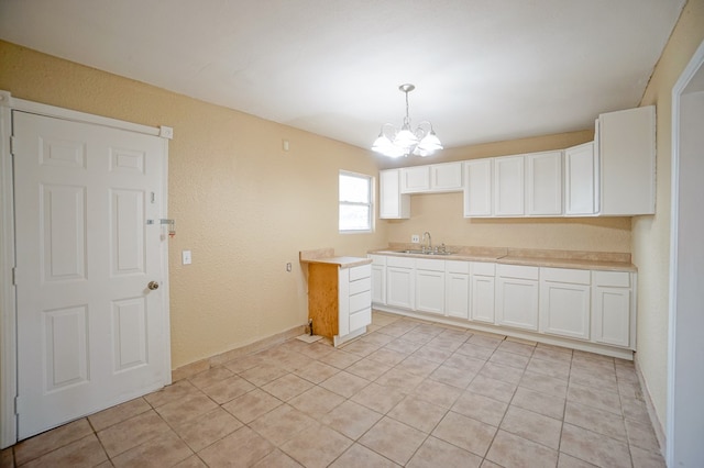 404W Jax Ave, Midland, TX 79701 - kitchen with a chandelier, light tile patterned floors, white cabinets, light countertops, and hanging light fixtures
