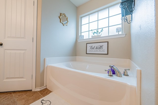 full bath featuring a garden tub, tile patterned floors, and baseboards