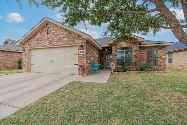 view of front of property with brick siding, driveway, an attached garage, a front lawn, and roof with shingles