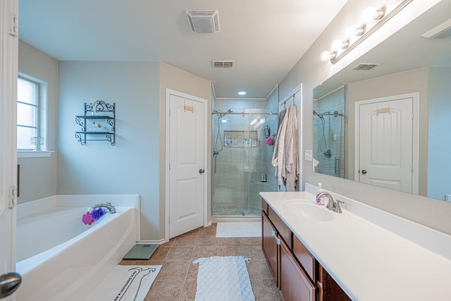 bathroom featuring a shower stall, vanity, a garden tub, tile patterned floors, and baseboards