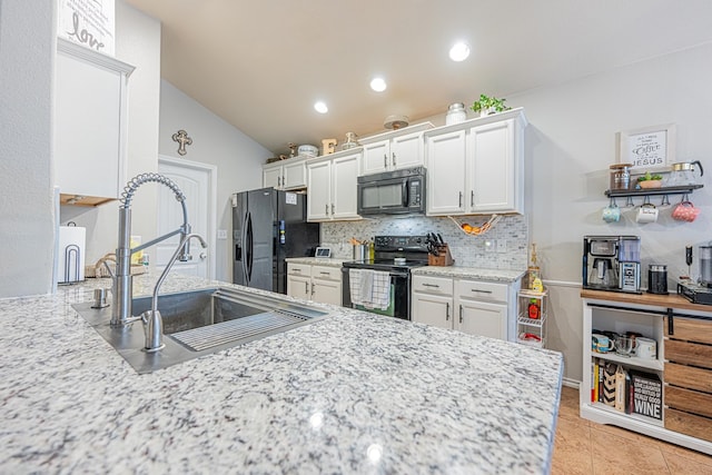 kitchen with black appliances, a sink, tasteful backsplash, white cabinetry, and lofted ceiling