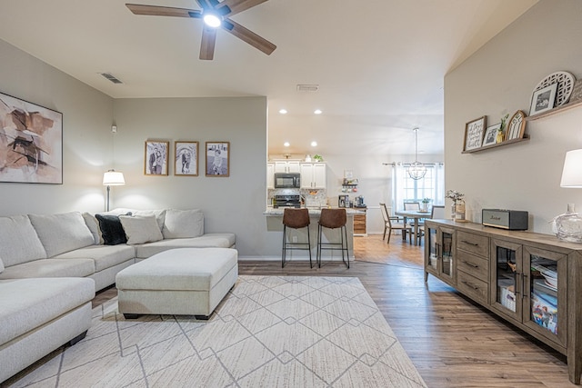 living room featuring ceiling fan, light wood-style floors, recessed lighting, and baseboards