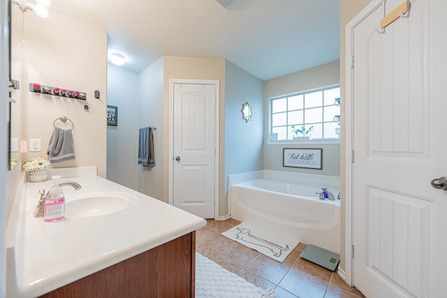 full bathroom featuring a garden tub, tile patterned floors, and vanity