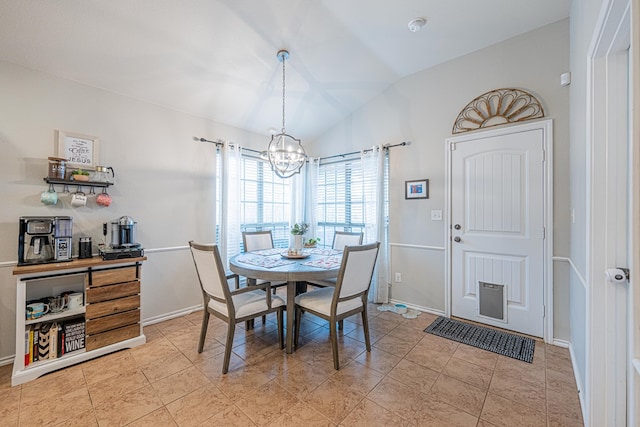 dining space with a chandelier, lofted ceiling, light tile patterned flooring, and baseboards